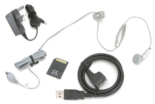 Accessories for Nokia 9300 smartphone displayed on a white background, including a power charger, earphones with inline microphone, memory card, and USB data cable.