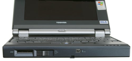 Toshiba Libretto U100 small-sized laptop with a partially open lid, revealing the keyboard and screen with visible USB ports and branding stickers on the palm rest.