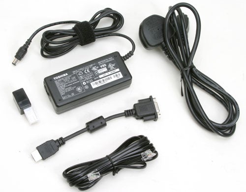 Toshiba laptop power adapter with various cables and connectors displayed on a light background.