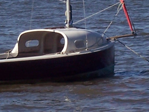 A small sailboat with a dark hull floating on water, possibly taken with the Kodak EasyShare C360, displaying moderate image clarity and detail.