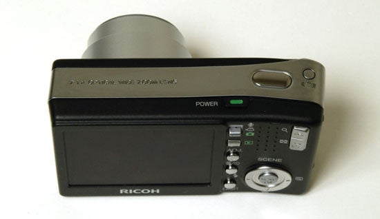Ricoh Caplio R3 digital camera displayed on a white background showing the lens barrel, power button, control buttons, and LCD screen.