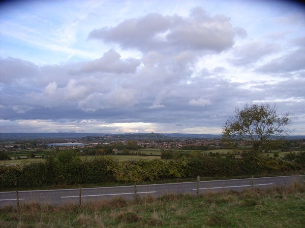 Landscape photograph taken with Ricoh Caplio R3 showcasing a view over a rural area with expansive cloudy sky and distant townscape.