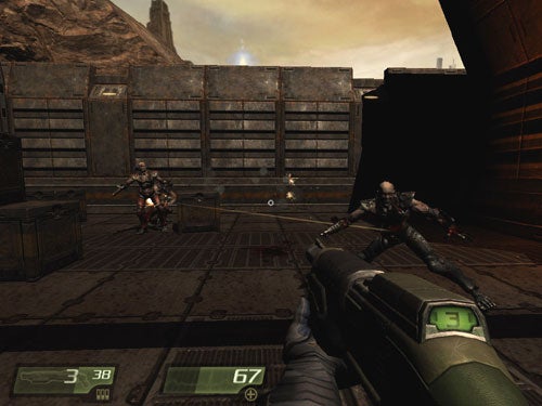 First-person perspective screenshot from the video game Quake 4 showing a player's character wielding a gun, with two enemy characters in the distance in a sci-fi industrial environment.