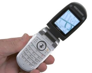 A hand holding an NEC N411i i-mode phone with the flip cover open, displaying a map on the screen.