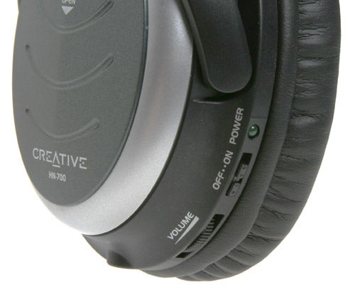 Close-up view of Creative HN-700 noise-cancelling headphones focusing on the side control panel with labels for noise cancellation and volume adjustment.