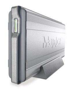 Maxtor Shared Storage Drive standing vertically on a desk with the brand logo embossed on the front and LED indicators visible on the side.