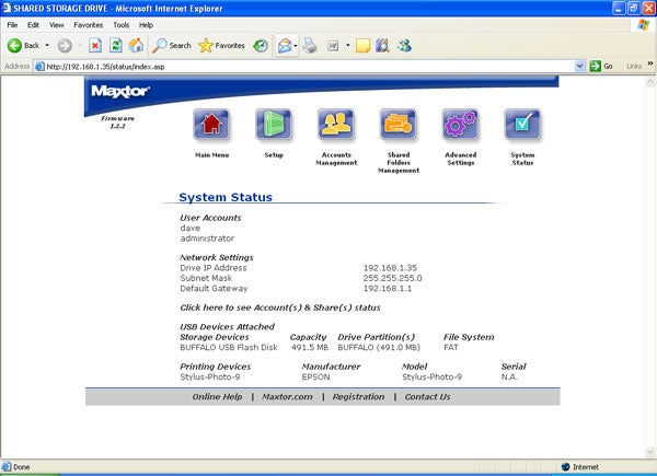 Screenshot of the Maxtor Shared Storage Drive web interface displayed in Internet Explorer showing the System Status tab with information on user accounts, network settings, attached USB devices, storage devices, and printing devices.