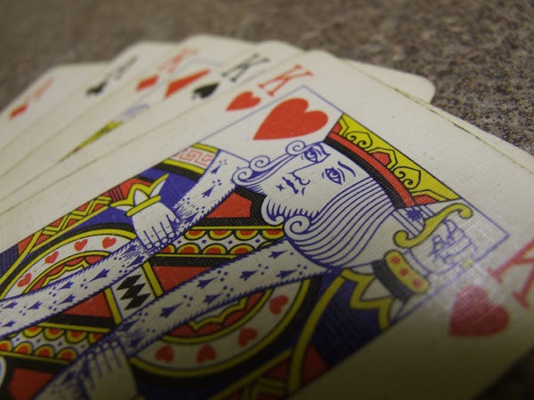 A close-up photograph of a King of Hearts playing card with a shallow depth of field, showcasing a detailed texture and vibrant colors.
