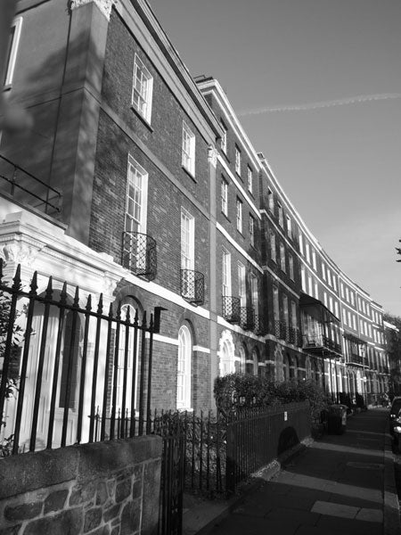 Black and white image of a row of traditional Georgian terraced houses with iron railings in the foreground, taken with a Fujifilm FinePix S9500 camera.