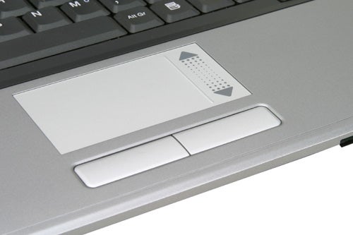 Close-up of a laptop touchpad and buttons with braille-like texture on the wrist rest area indicating features for visually impaired users.
