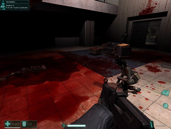 Screenshot from the video game F.E.A.R. First Encounter Assault Recon showing a first-person view where the player character holds a gun, with a squadmate crouched ahead amidst a blood-stained environment and a dead enemy on the floor.
