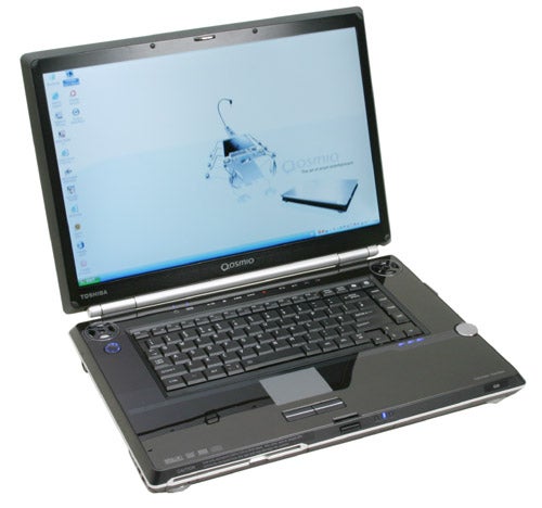 Toshiba Qosmio G20 laptop open on a flat surface displaying the desktop on the screen, with a visible Qosmio wallpaper, and physical media control buttons below the screen.