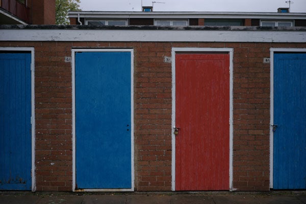 Three adjacent doors in a brick wall, from left to right colored blue, red, and blue, demonstrating the color reproduction and sharpness of an image taken with the Epson R-D1 digital rangefinder camera.