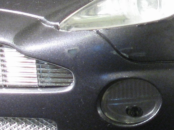 Close-up of a toy car's front end showing the headlights, grille, and part of the bumper.