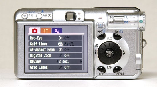 Canon PowerShot S80 camera showing its settings menu on the LCD screen, which includes options for red-eye reduction, self-timer, AF-assist beam, digital zoom, review time, and grid lines.