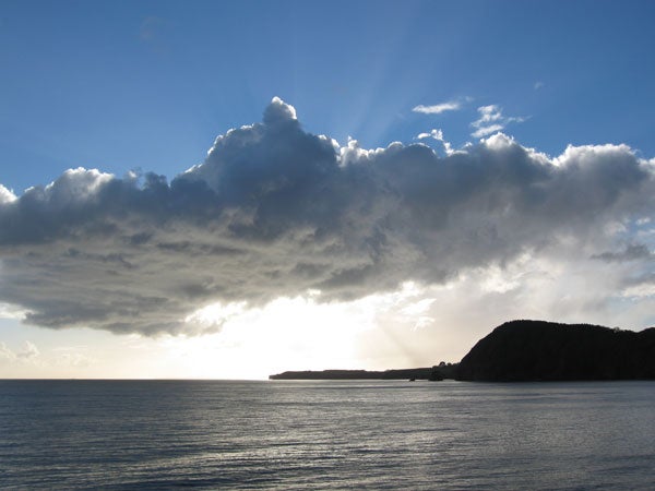 Photograph of a seascape with sunlight piercing through clouds taken with a Canon PowerShot S80 camera.