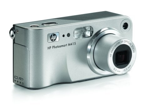 HP Photosmart M415 digital camera with lens extended, showcasing its compact silver body and branding.