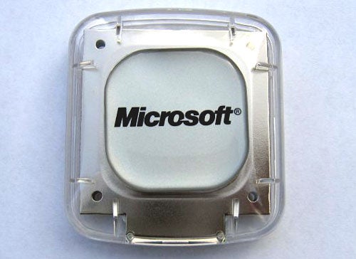 Microsoft Autoroute 2006 GPS locator device with clear plastic casing and the Microsoft logo displayed on the front.