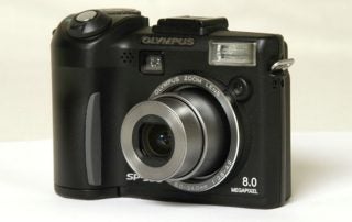 Olympus SP-350 digital camera with 8.0 megapixel resolution, front profile showing lens, flash, and controls.