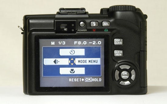 Olympus SP-350 digital camera's back view showing its LCD screen displaying the mode menu and various control buttons.