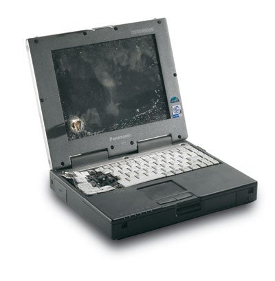 Panasonic ToughBook CF-29 rugged laptop with visible signs of wear and a bullet hole through the screen, highlighting its durability.