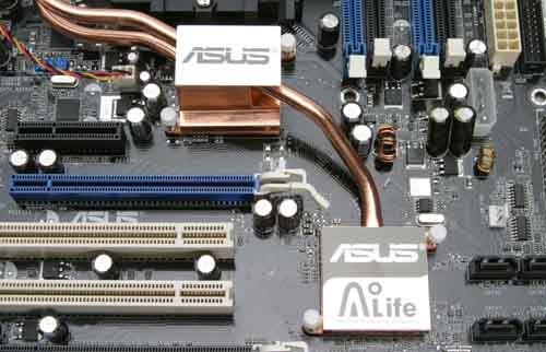 Close-up view of Asus A8N32-SLI Deluxe motherboard highlighting the copper heat pipes and chipset cooling systems with ASUS branding.