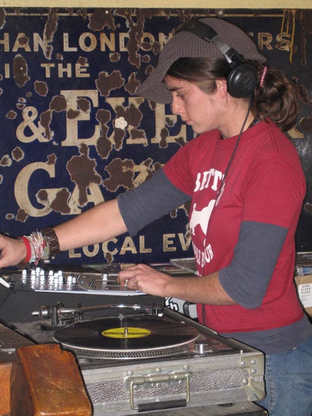A person DJing with vinyl records on two turntables.