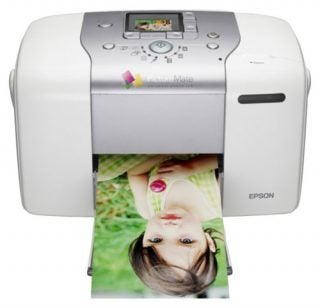 Epson PictureMate 100 portable photo printer with a printed color photograph emerging from the output slot.