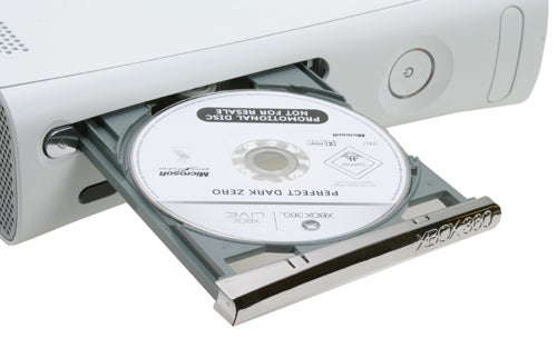 A Microsoft Xbox 360 console with its disc tray ejected, showing a game disc halfway inserted.