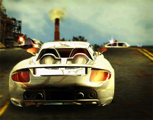 A silver sports car being chased by police vehicles in a high-speed pursuit from the video game Need for Speed: Most Wanted 2005.