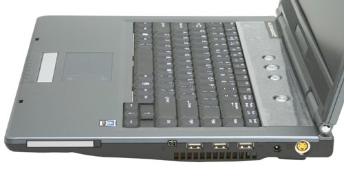 Alienware Area-51 m5500 laptop with a view of the keyboard, touchpad, and left-side ports including USB, audio, and video outputs on a gray surface.
