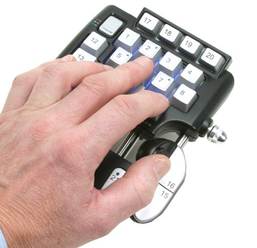 A hand using the Saitek Pro Gamer Command Unit, showcasing its button layout and joystick control.