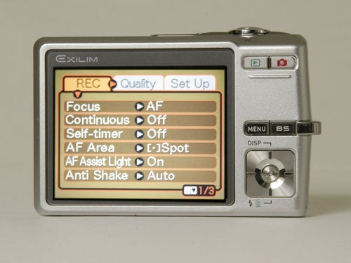 Casio Exilim EX-Z500 digital camera displayed from the back showing the LCD screen with menu settings including focus, self-timer, AF area, and anti-shake options.