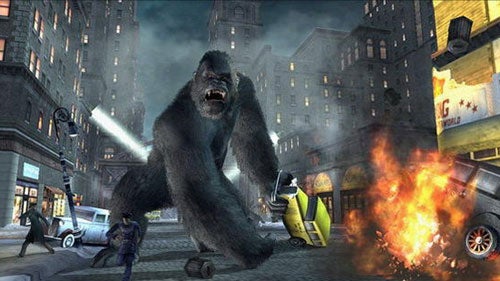 King Kong towering over a city street with damaged vehicles and fire, likely from a video game or a promotional graphic for a King Kong-themed product.