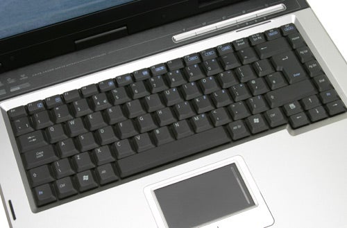 Close-up view of the keyboard and touchpad of an Asus A6Km-Q002H laptop with silver accents and trackpad buttons visible.