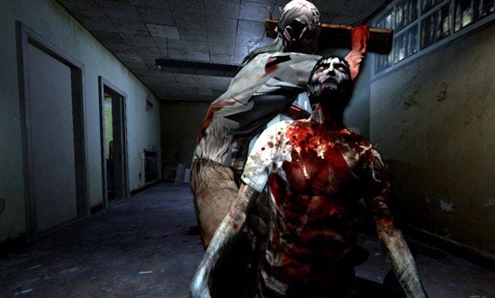 Screenshot from the video game Condemned: Criminal Origins showing a first-person view of a character experiencing an attack from behind by a bloody, zombie-like enemy in a dilapidated corridor.