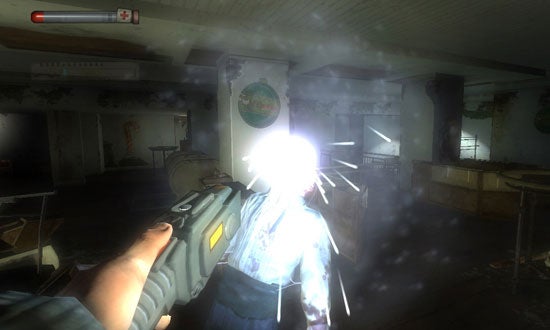 First-person perspective in-game screenshot from Condemned: Criminal Origins showing the character's hand holding a firearm with a bright muzzle flash as it is being discharged at an enemy in an abandoned room environment.