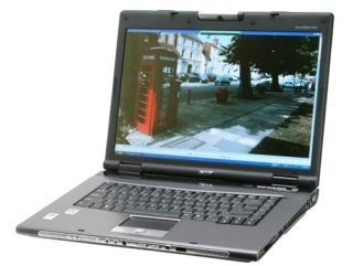 Acer TravelMate 8204WLMi notebook open with a photo on the screen, featuring a full keyboard and touchpad visible.