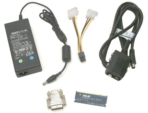 ASUS power adapter, various cables, and a Molex to PCIe power adapter with an ASUS sticker, potentially accessories for an ASUS Extreme Dual N7800GT graphics card.