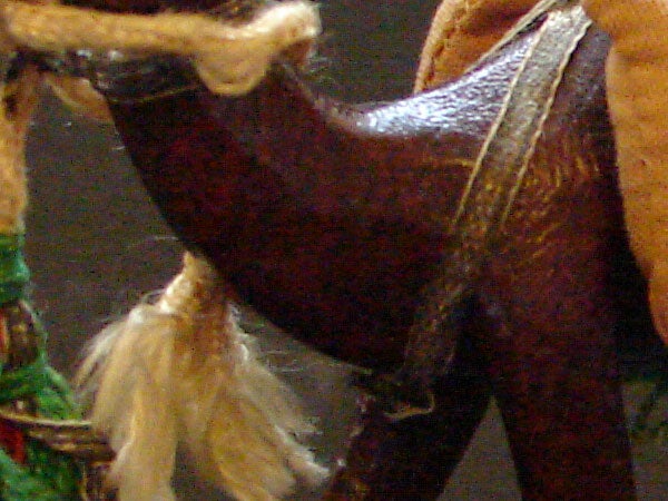 Close-up of a saddle on a toy horse.