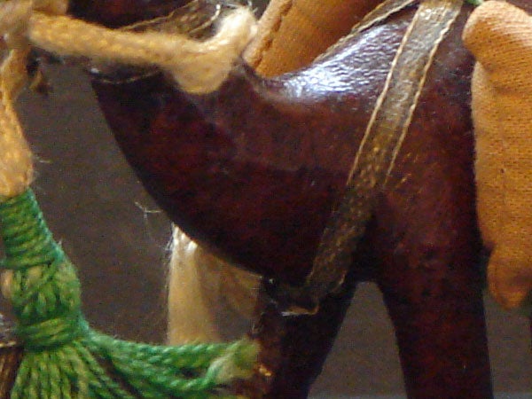 Close-up of a toy horse's saddle and rope detail.