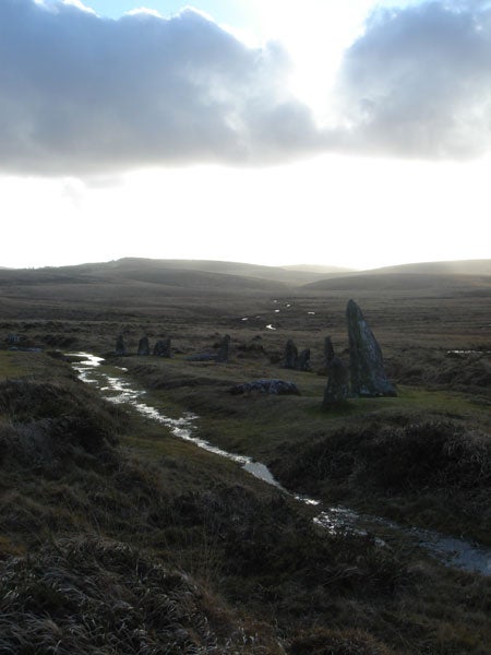 Landscape photo with standing stones and cloudy skies.