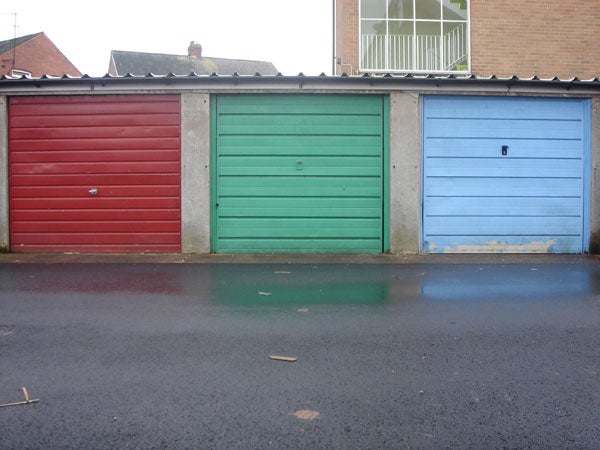 Three colorful garage doors in a row on a cloudy day