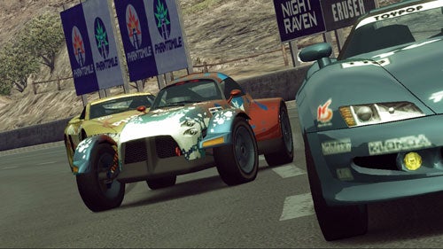 Screenshot from the video game Ridge Racer 6 showing two racing cars competing on a track, with in-game sponsorship banners in the background.
