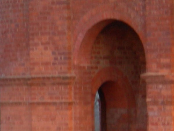 Image of an arched brick passageway with soft focus, possibly taken with a Nikon CoolPix P1 Wi-Fi Compact Camera showcasing depth of field capabilities.