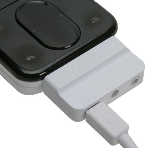 Close-up of a Creative Zen Vision: M portable media player connected to a white USB cable with a Creative USB adapter.