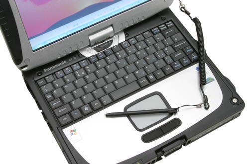 Panasonic ToughBook CF-18 rugged notebook with a stylus pen attached to the corner, showing its keyboard and partially visible screen with a colorful display.