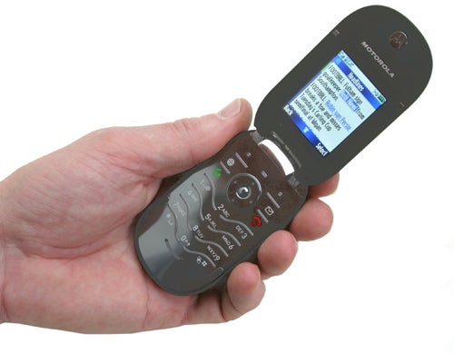 Hand holding an open Motorola PEBL mobile phone showing the screen and keypad.