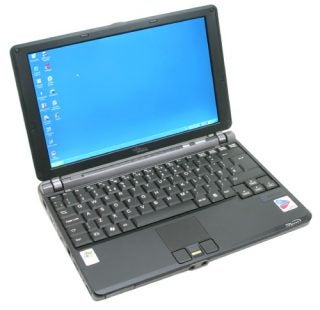 Fujitsu-Siemens Lifebook P7120 laptop open on a plain surface with the screen displaying a blue background and desktop icons, featuring a black keyboard and trackpoint.