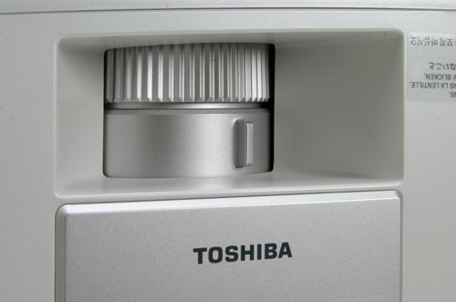 Close-up of Toshiba TDP-MT700 HD projector focusing on lens adjustment controls.